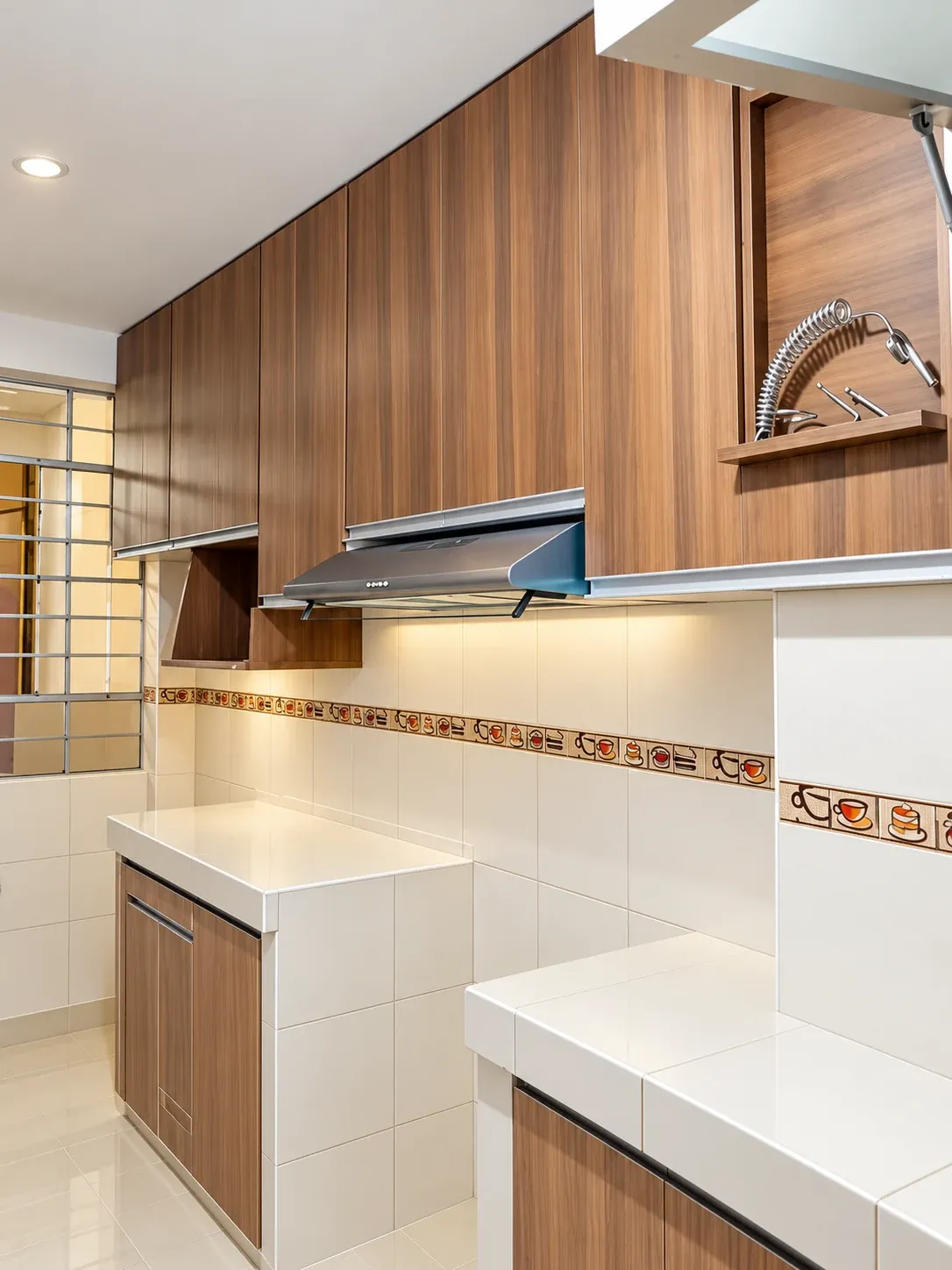 Cocina con acabado madera, campana y muebles superiores sobre encimeras revestidas de baldosas claras.